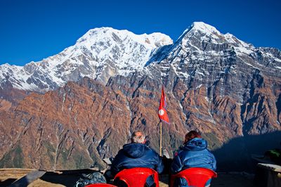 Senior couple sitting on the ridge in himalayas mountains, nepal