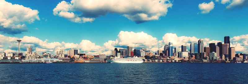 Panoramic view of cityscape by sea against sky