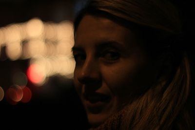 Close-up portrait of mid adult woman at night