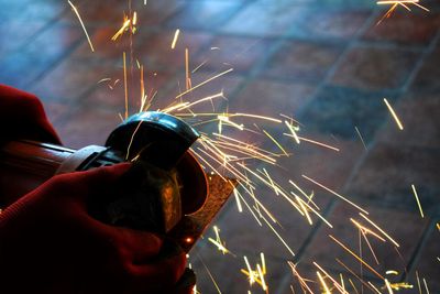 Close-up of hand holding sparkler at night