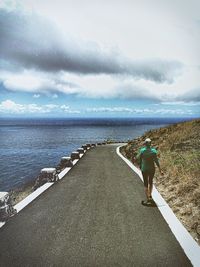 Rear view of man walking on beach