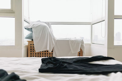 White clothes hanging on bed against wall at home