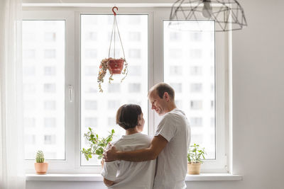 Couple standing against window