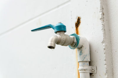 Close-up of faucet against white wall