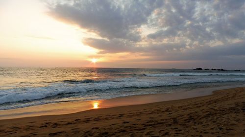 Scenic view of beach against sky during sunset