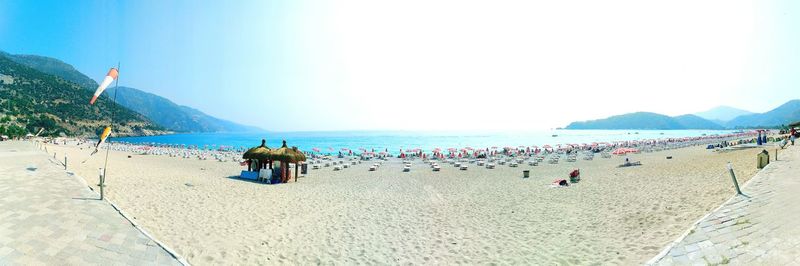 People on beach against clear sky