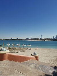 Scenic view of beach against clear blue sky