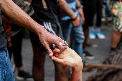 Midsection of people holding hands in city