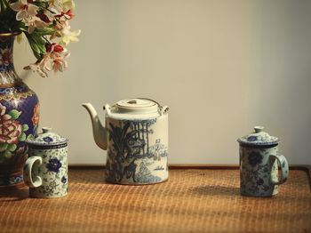 Close-up of vase on table against wall