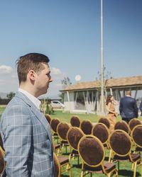 Young man looking at camera against clear sky