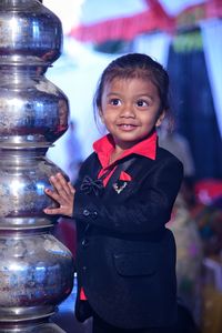 Cute baby boy standing by metal containers during wedding ceremony