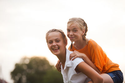 Portrait of happy friends against sky