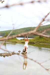 Woman sitting on rock at lake