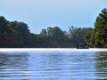 Scenic view of sea with trees in background