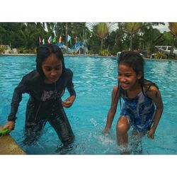 Portrait of siblings playing in swimming pool