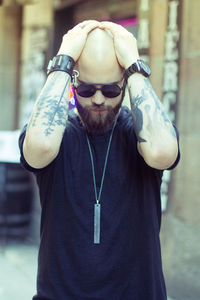 Portrait of young man wearing sunglasses standing outdoors