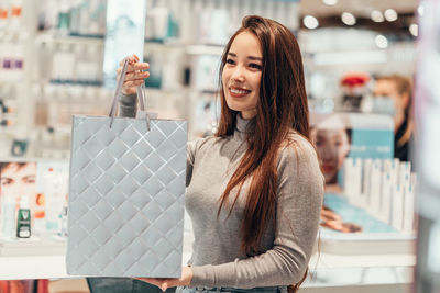 Portrait of smiling young woman standing in store