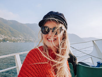 Close-up portrait of smiling young woman in sea against sky