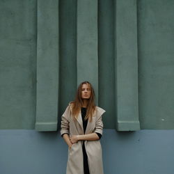 Full length of young woman against wall