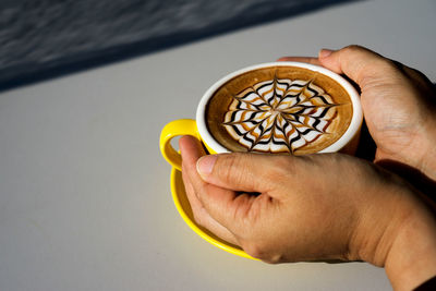 Close-up of hand holding coffee cup