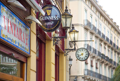 Low angle view of clock amidst buildings in city