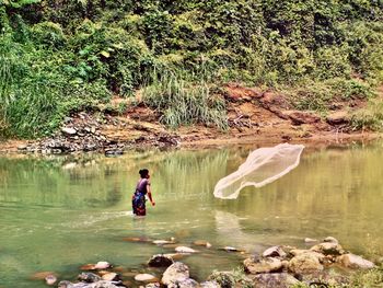 A tribal woman catches fish in the sangu river at thanchi bandarban.