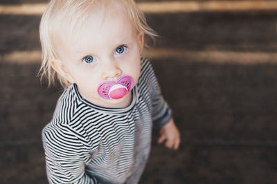 High angle view of girl with pacifier standing outdoors