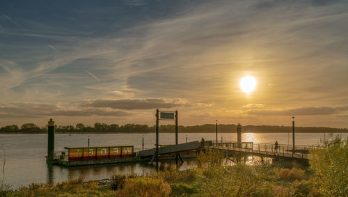 Scenic view of river against sky during sunset