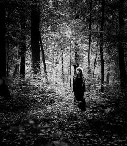 Man standing on tree trunk in forest