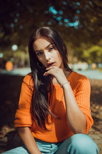 Young woman looking away while sitting outdoors