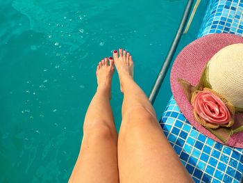 Low section of woman relaxing in swimming pool