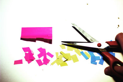 Close-up of hand holding paper over white background
