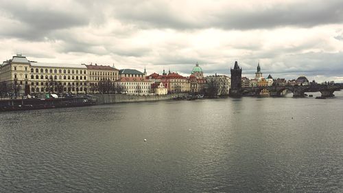 Bridge over river in city against sky