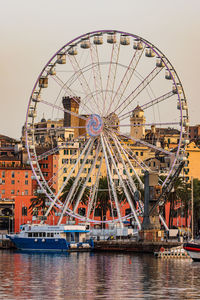 A giant touristic ferris wheel in the old harbour of genoa, italy
