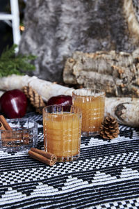 Apple spiced cider served on ice with apple and cinnamon