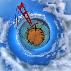 Digital composite image of ferris wheel against blue sky