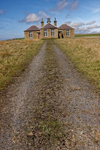 Building on field against sky