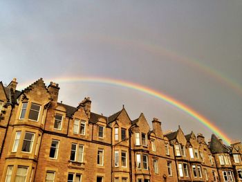 Low angle view of rainbow in city against sky