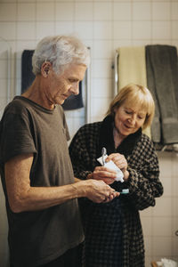 Senior couple brushing teeth at home