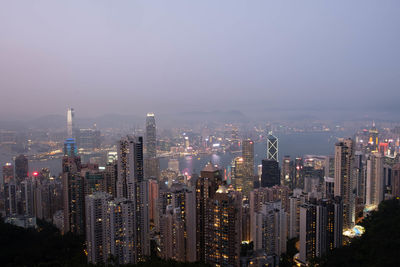 Illuminated buildings in city against sky