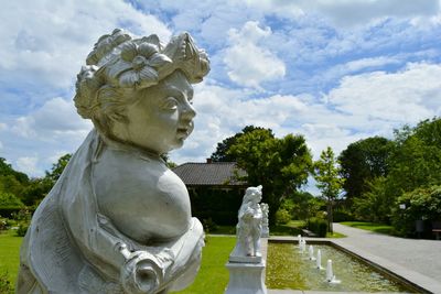 Statue by trees against sky