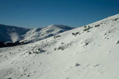 Scenic view of snowcapped mountains against clear blue sky