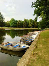 Boats moored in lake against sky