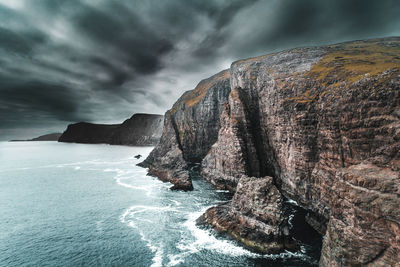 Rock formations by sea against sky