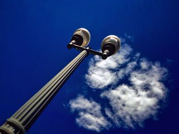 Low angle view of street light against blue sky