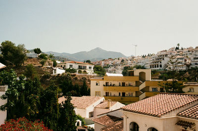 High angle view of houses in town against clear sky