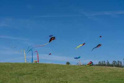 Low angle view of people on field against sky