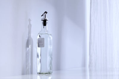 Close-up of glass bottle against wall