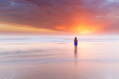 Full length of man standing on beach during sunset