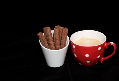 Close-up of coffee cup on table against black background